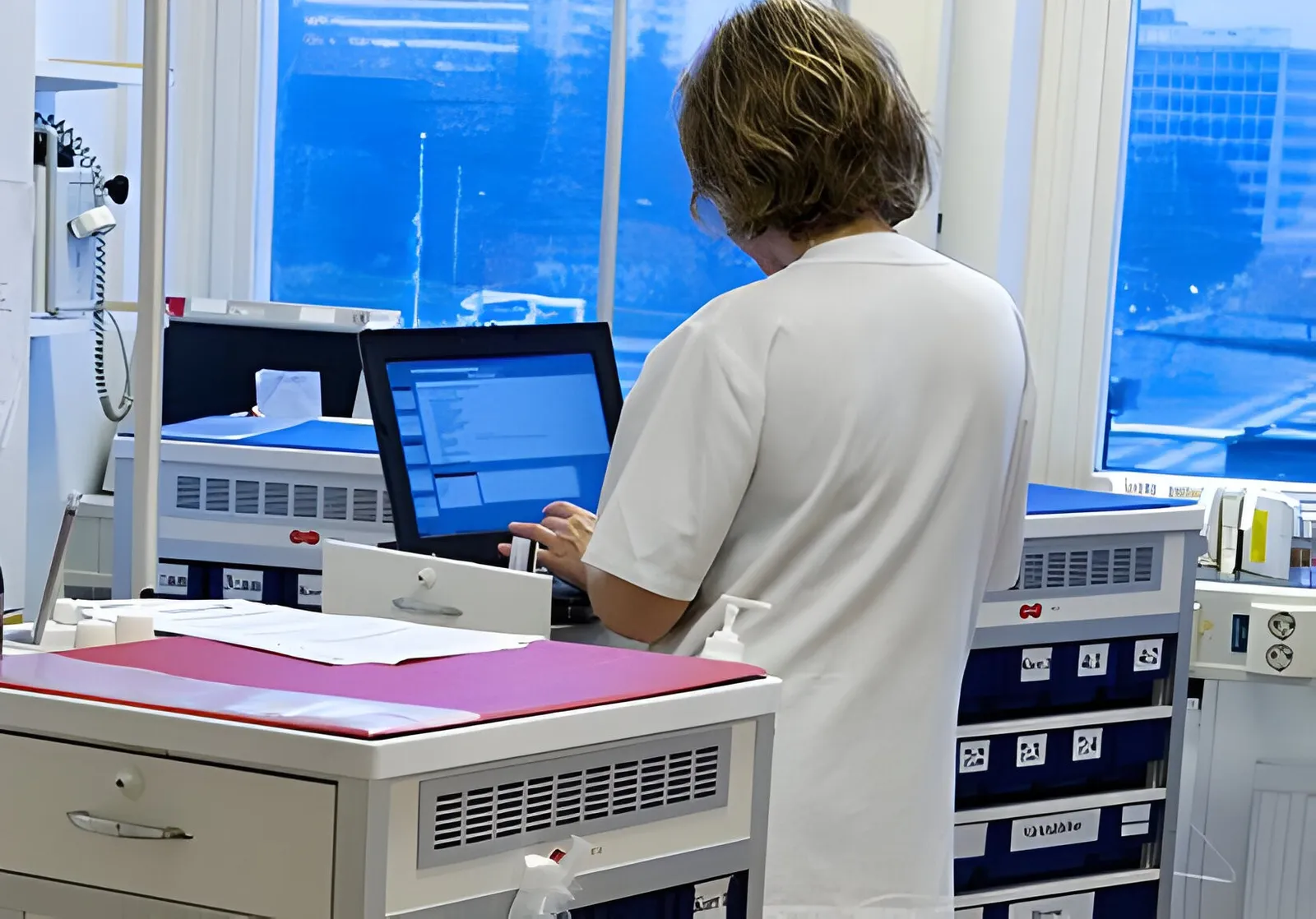 A nurse working at a hospital computer terminal during a research site visit