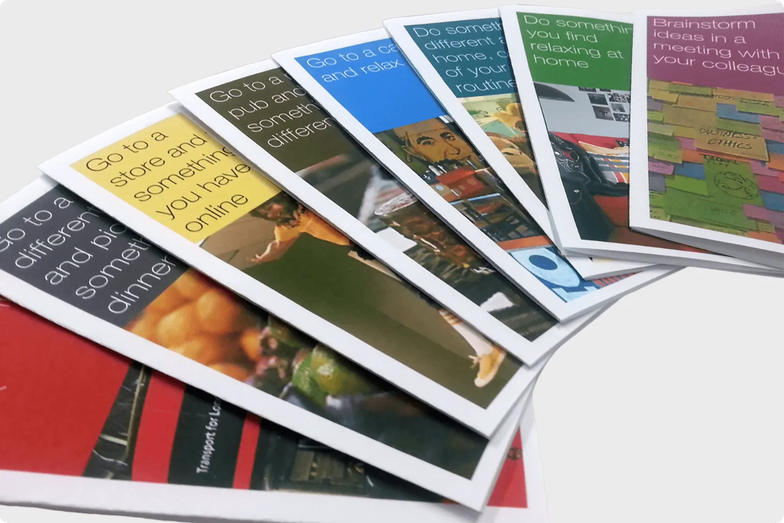 A fanned-out set of physical 'stimulus' cards, each printed with a prompt such as 'Go to a store and pick something different for dinner', used to spark opportunity-area thinking
